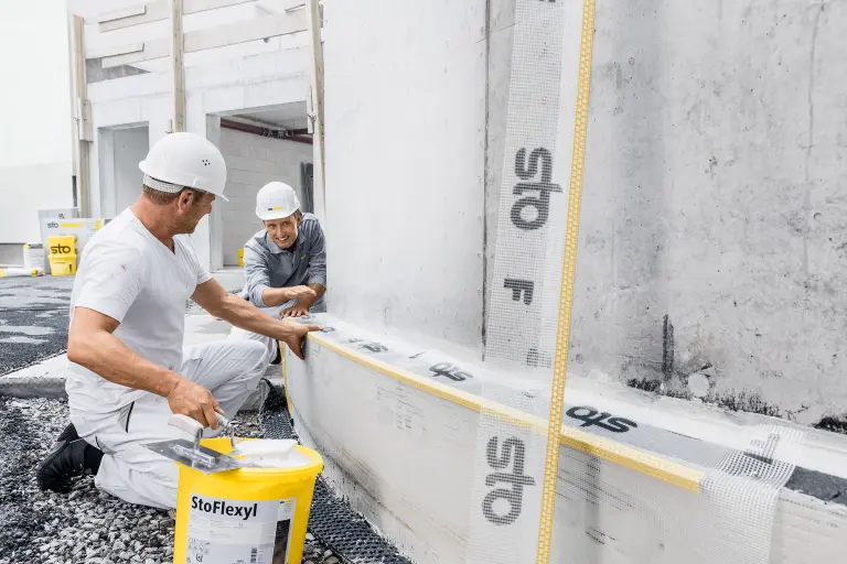 Fortbildung, Beratung, Partnerschaft, Sto-Verkaufsberater und Handwerker auf der Baustelle