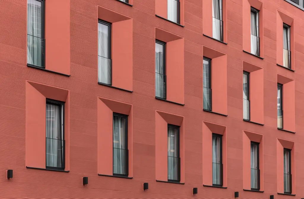 Workshop-Teilnehmer bei praktische Anwendungen mit dem Baumaterial Putz. Im Freien auf Tischen.