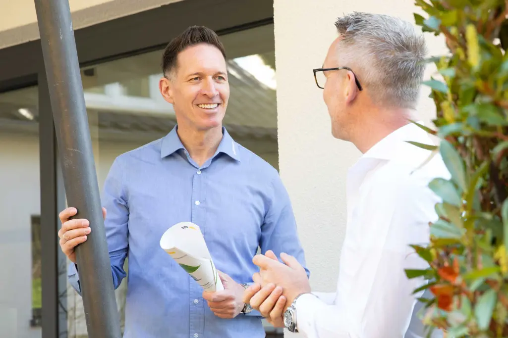 Fachhandwerker im Dialog mit Sto-Verkaufsberater zum Thema nachhaltige Fassadendämmung