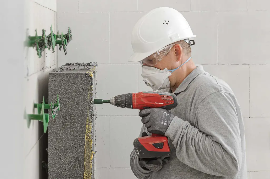 Ein Mann montiert rückbaubares WDVS ab