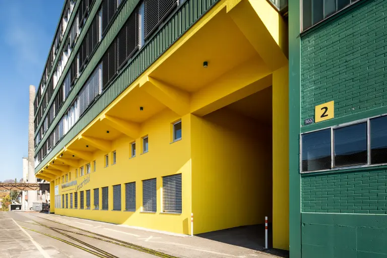 Detailaufnahme einer grün-gelben Industriebau-Fassade, beschichtet mit der Fassadenfarbe StoColor Dryonic®