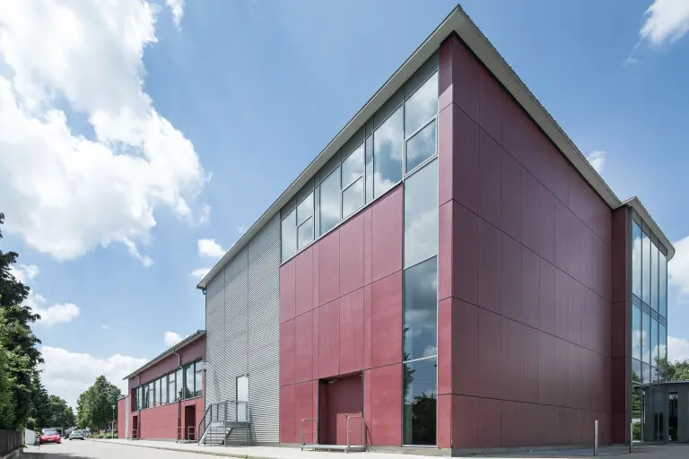 Außenaufnahme eines sanierten Verwaltungsgebäudes mit rot-grauer Metallic-Fassade beschichtet mit der Fassadenfarbe StoColor Dryonic®