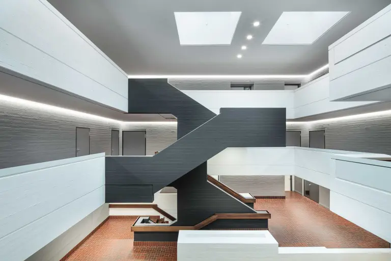 Foyer einer gewerblichen Schule, Wände und Decke in Grau gehalten, Decke mit Akustiksystem von Sto ausgestattet: StoSilent Distance