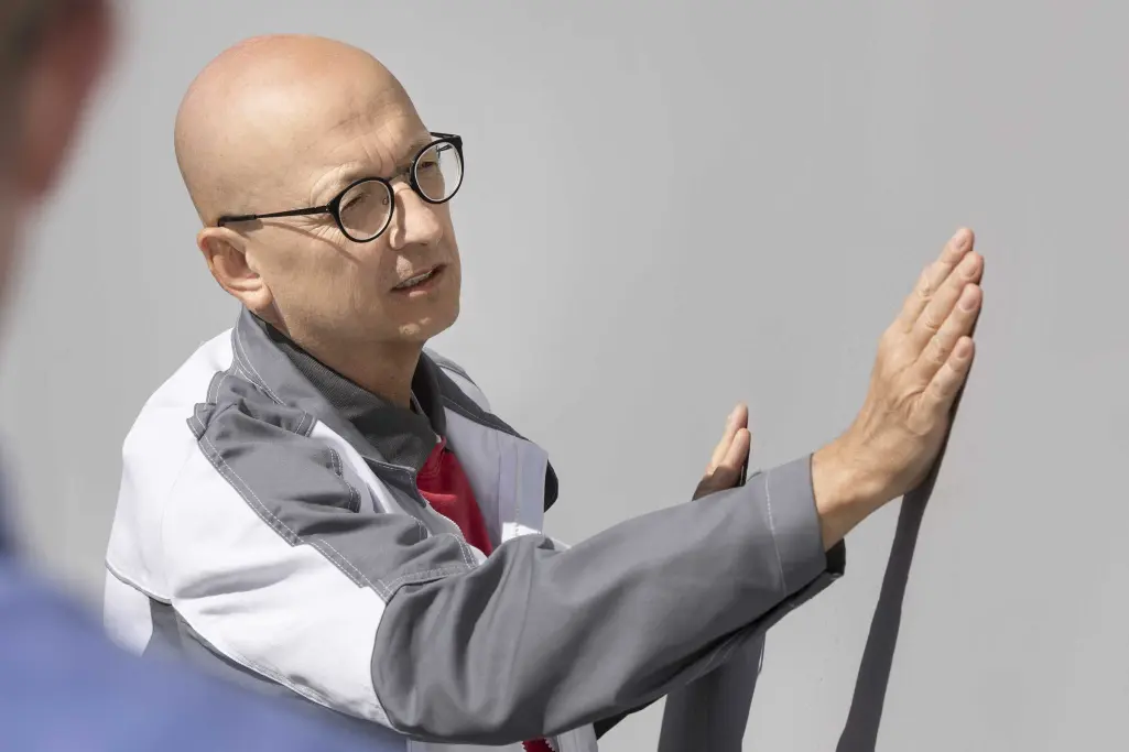 Sanierung Nichtwohnbaugebäude - Handwerksprofi streicht mit der Hand über Außenwand