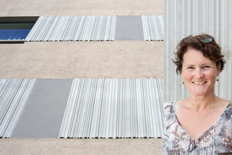 Graue Fassade mit plastischen StoDeco Elementen, daneben Architektin 