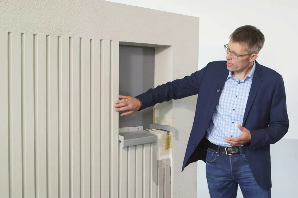 Projektleiter Dirk Meier-Plate vor einer Musterfläche, gestaltet mit plastischen Fassadenelementen