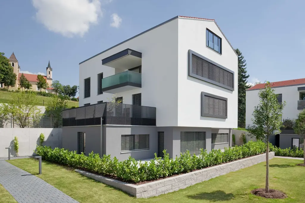 Wohnanlage, weiße Fassade gedämmt mit CO₂-optimiertem WDVS StoTherm Wood mit Holzfaserdämmung