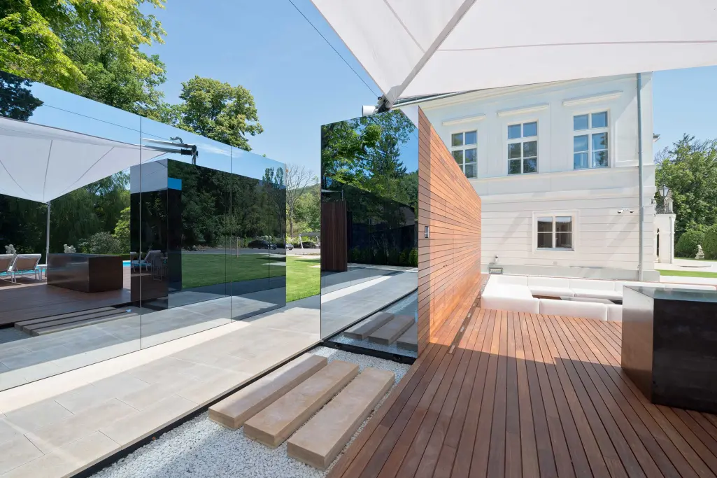 Glasfassade Details: Verspiegelte Glasfassade eines Poolhauses mit historischem Gebäude