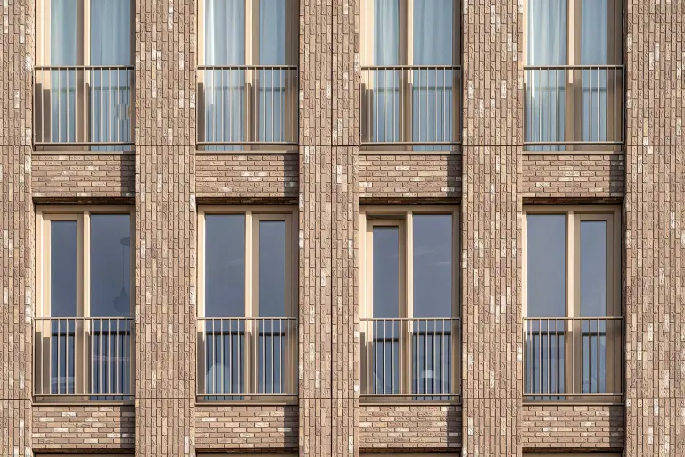 Detailaufnahme eines Geschäftsgebäudes, beigefarbene gedämmte Fassade, bekleidet mit Flachverblendern von Sto