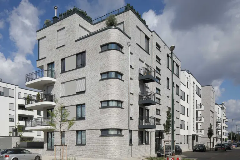 Außenaufnahme einer Wohnanlage, gedämmte, graue Sto-Fassade, mit StoBrick Klinker bekleidet