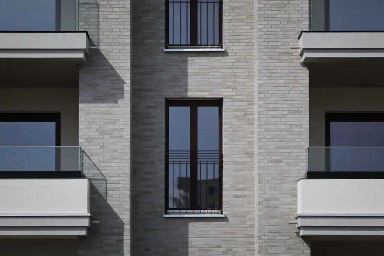 Außenaufnahme einer Wohnanlage, beigefarbene Klinkerfassade, mit Sto gedämmt und StoBrick Klinkerriemchen bekleidet.