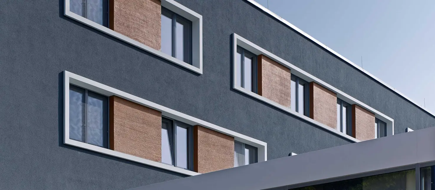 Fassadendämmung: Außenaufnahme eines Apartmenthauses, anthrazitfarbene, mit Sto gedämmte Fassade