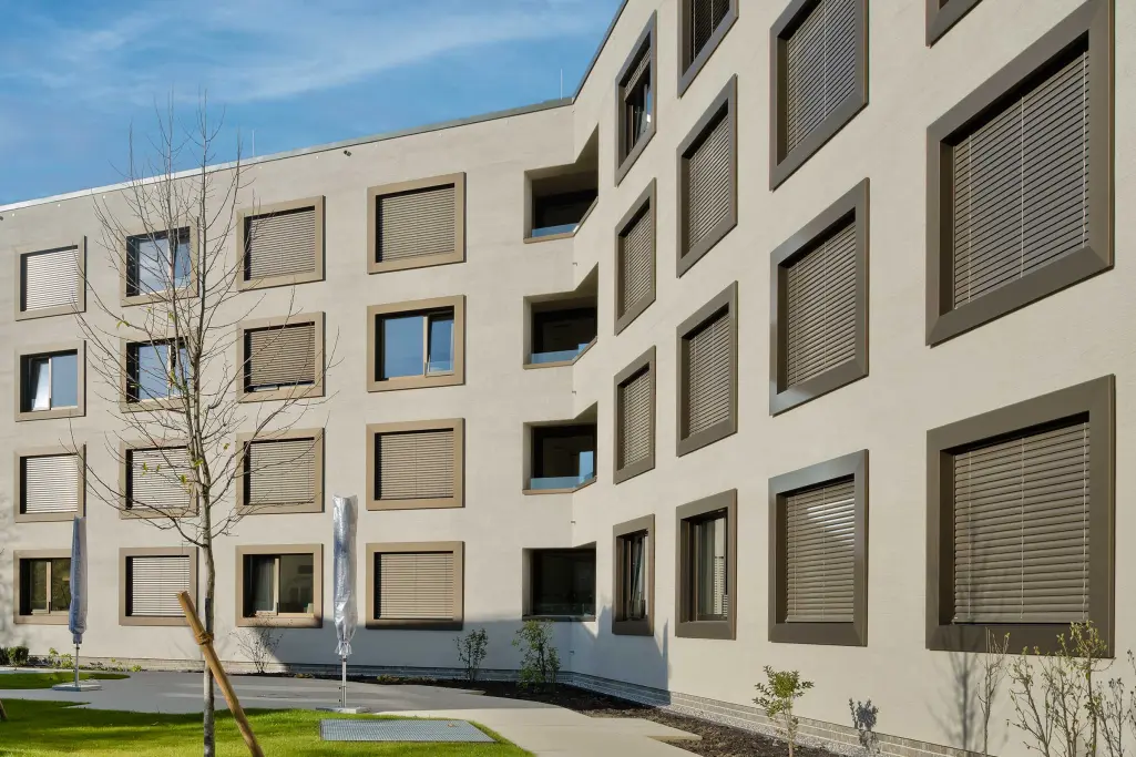 Außenaufnahme eines Seniorenheims, beige-graue Fassade gedämmt mit Mineraldämmplatte von Sto