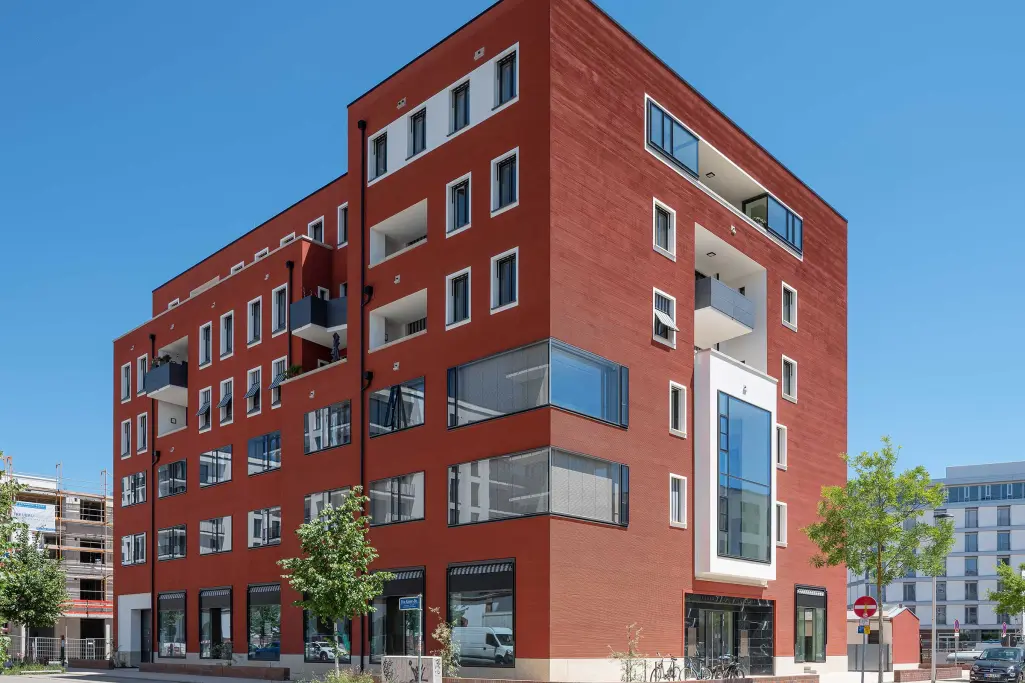 Wohn- und Geschäftshaus mit roter Fassade, gedämmt mit Mineraldämmplatte im System StoTherm Cell
