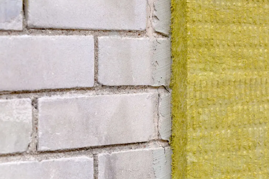 Außenwand eines Gebäudes wird mit Mineralwolle gedämmt, Fassadendämmung mit Steinwolle