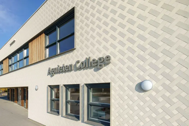 Außenaufnahme beigefarbene, gedämmte Putzfassade, bekleidet mit vorgefertigten Putzelementen StoEcoshapes