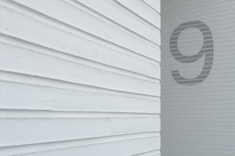 Detailaufnahme einer gedämmten weißen Putzfassade, bekleidet mit vorgefertigten Putzelementen StoEcoshapes
