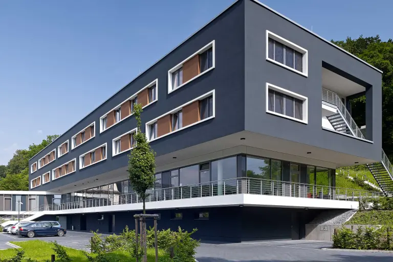 Außenaufnahme Wohngebäude, dunkle gedämmte Sto-Fassade mit StoDeco Elementen bekleidet