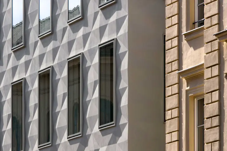 Detailaufnahme einer gedämmten grauen Fassade, gestaltet mit plastischen Fassadenelmenten von Sto: StoDeco