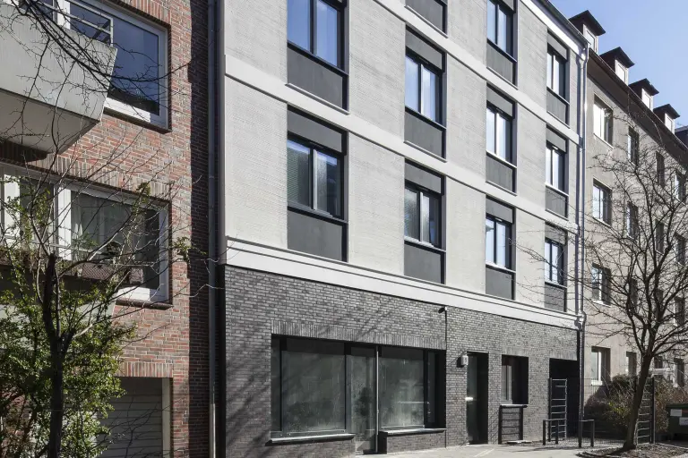 Detailaufnahme einer gedämmten grauen Fassade, beschichtet mit Sto-Materialien, Putz und StoDeco Architekturelemente