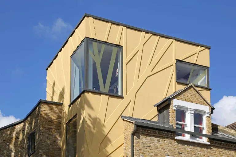 Detailaufnahme einer Gebäudefassade, gelb-braune Putz-Klinkerfassade, bekleidet mit plastischen Fassadenelementen von Sto