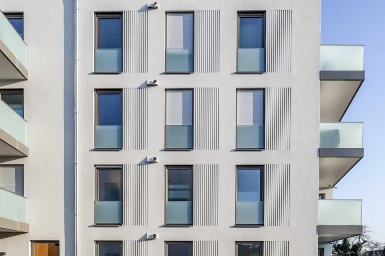 Außenaufnahme eines Wohngebäudes, weiße gedämmte Fassade, mit Putz und plastischen Fassadenelementen von Sto umgesetzt.