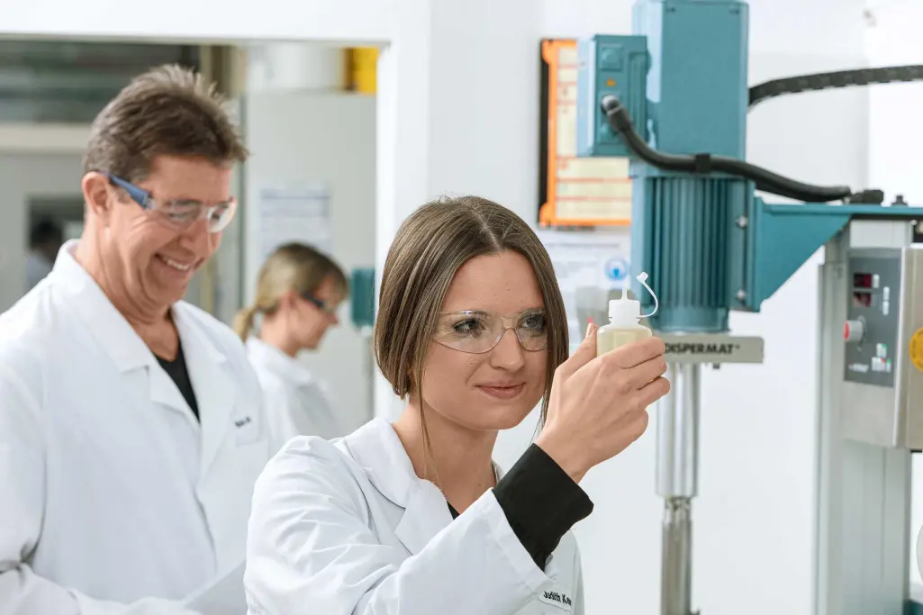 Berufseinsteiger und Erfahrene: Junge Mitarbeiter und erfahrener Sto-Mitarbeiter arbeiten im Labor 