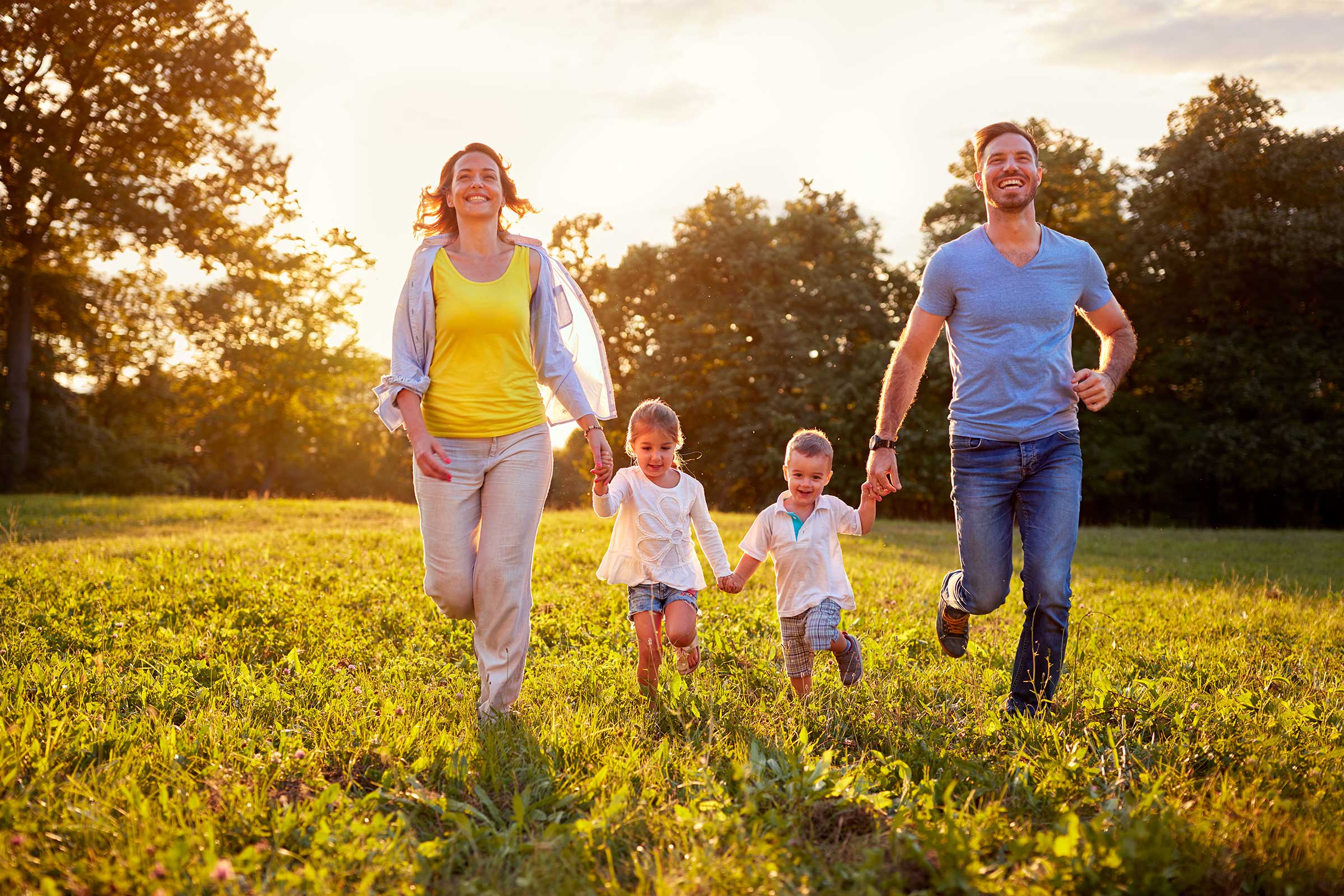 Work-Live-Balance Sto: Feierabend, Familie mit 2 Kindern in der freien Natur, laufen auf einer Wiese