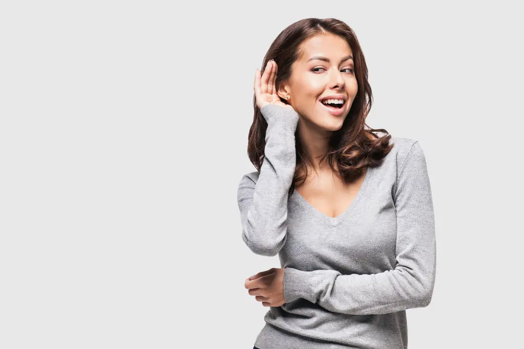 Frau hält eine Hand ans Ohr, um besser zu hören; Akustik; Wohlbefinden