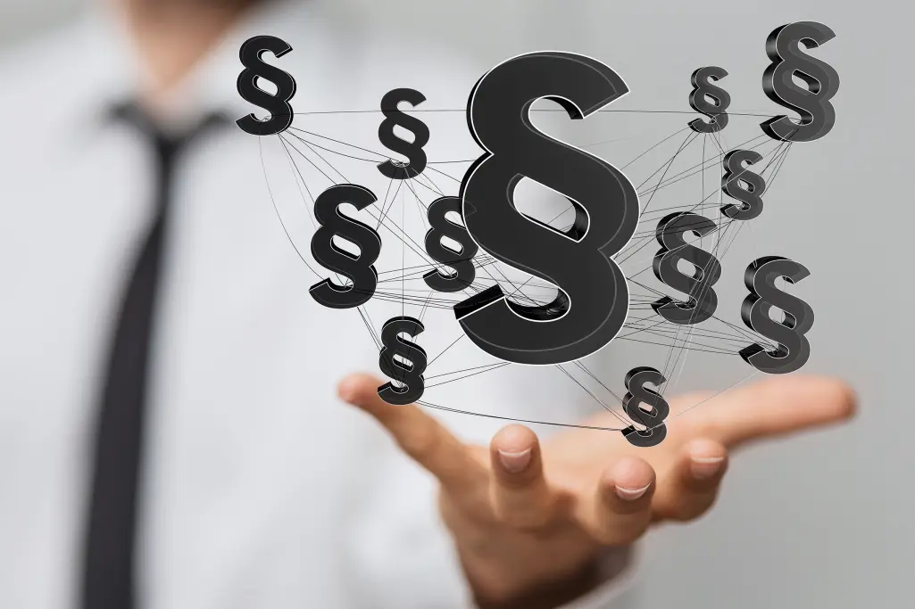 Geschäftsmann hält Paragrafen in der Hand, Einhaltung von Regeln und sozialen Standards