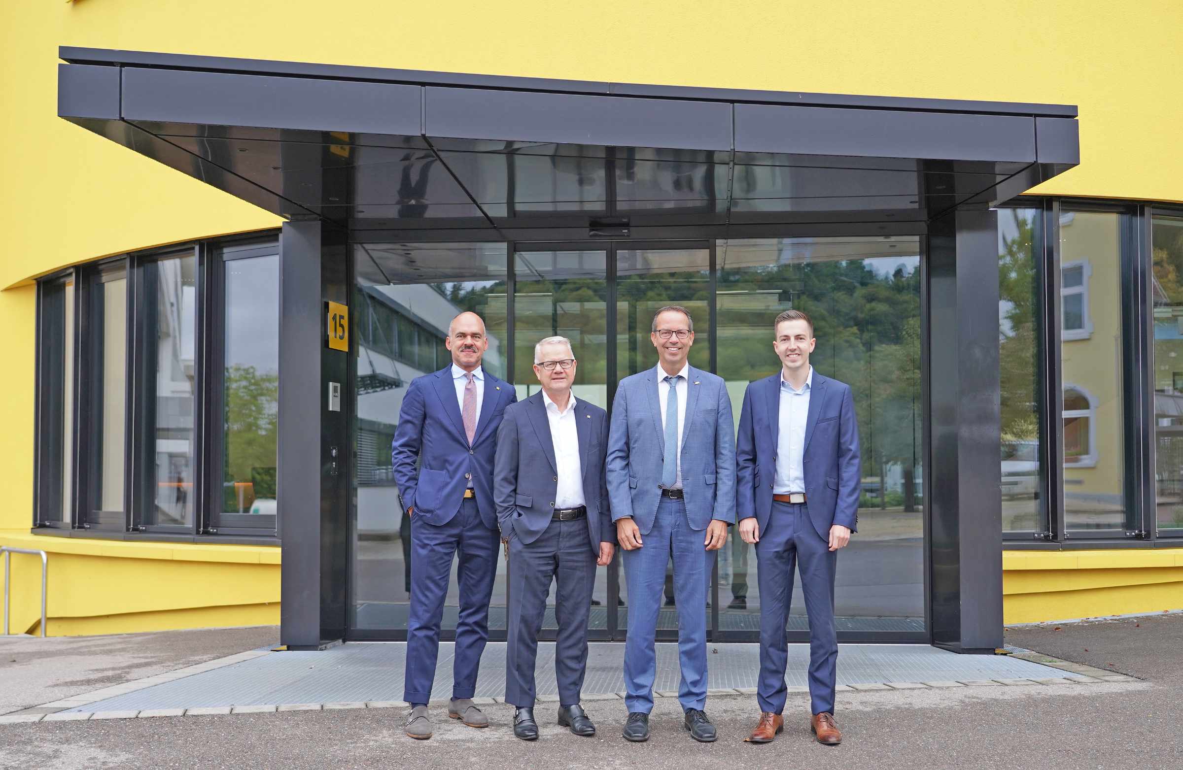 Gruppenbild mit vier Männern vor dem Sto-Gebäude