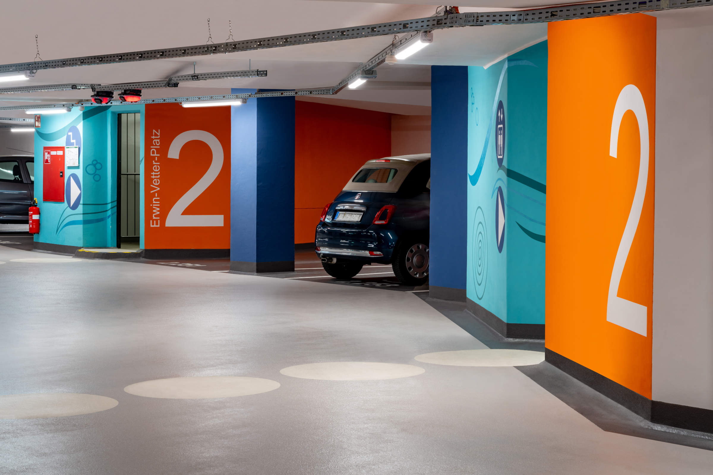 Tiefgarage mit farbigen Wänden und Bodenmarkierungen