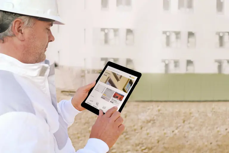 Handwerker mit Tablet. Er bestellt direct im Sto Onlineshop.