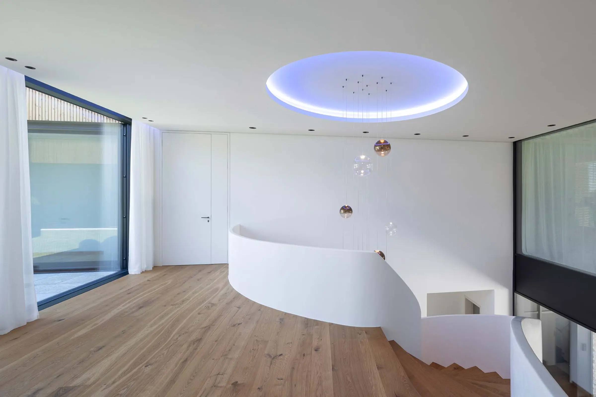 Innenaufnahme eines Einfamilienhauses, StoSilent Distance C, weißes Finish im Foyer mit Wendeltreppe