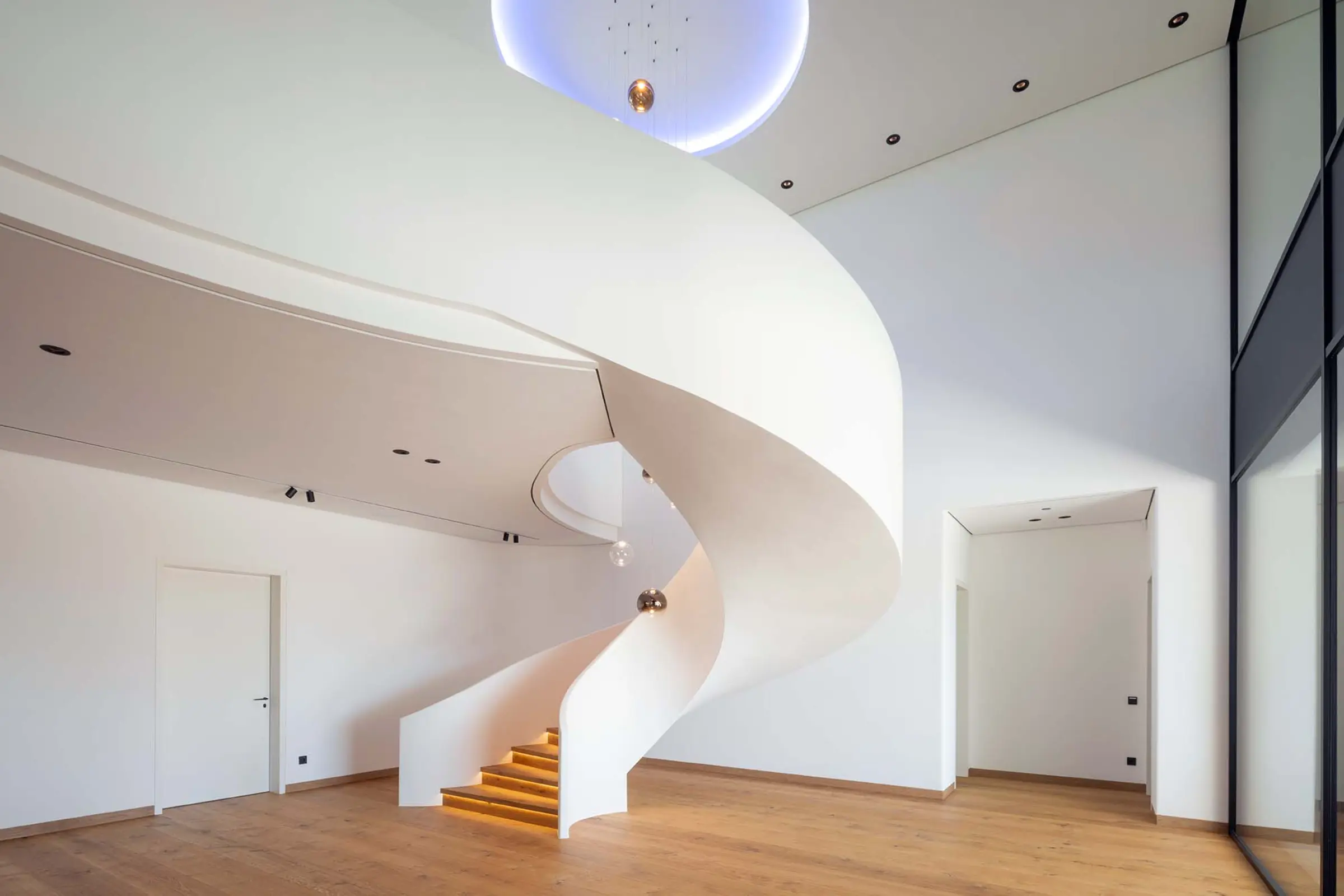 Innenaufnahme eines Einfamilienhauses, StoSilent Distance C, weißes Finish im Foyer mit Wendeltreppe