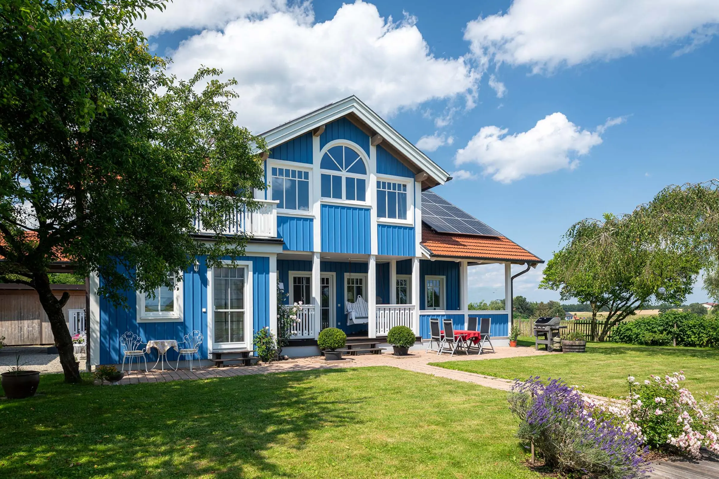 Aufnahme eines blauen Einfamilienhaus mit Garten, Fassaden-Sanierung mit StoColor Dryonic® Wood