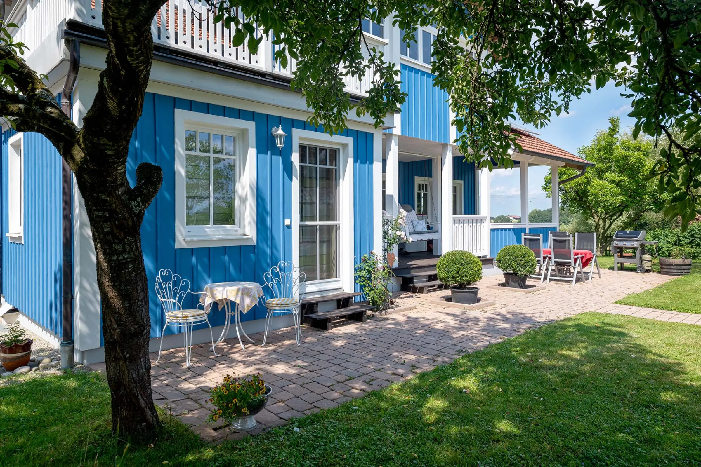 Aufnahme eines blauen Einfamilienhaus mit Garten, Fassaden-Sanierung mit StoColor Dryonic® Wood