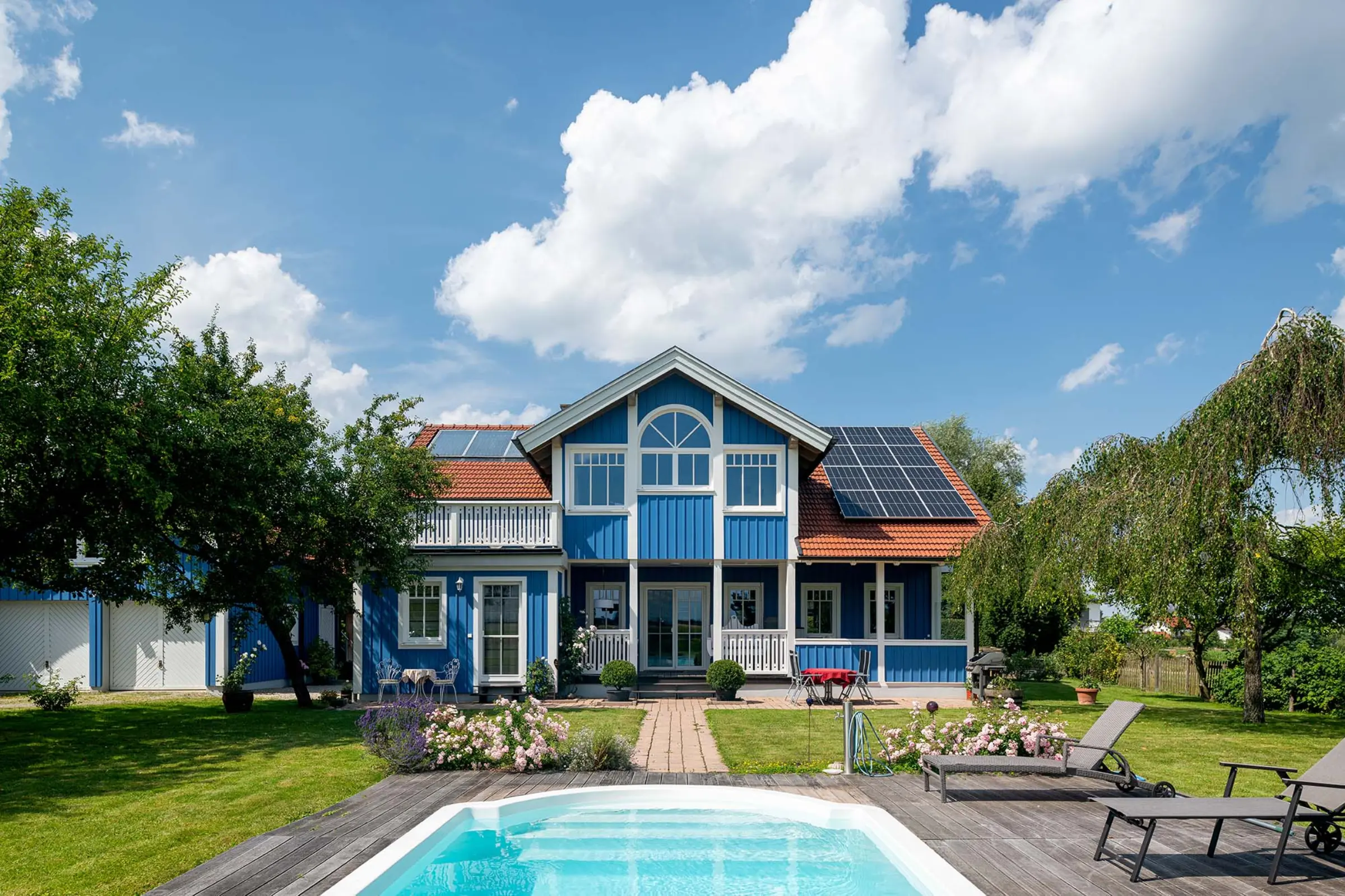 Aufnahme eines blauen Einfamilienhaus mit Pool, Fassaden-Sanierung mit StoColor Dryonic® Wood