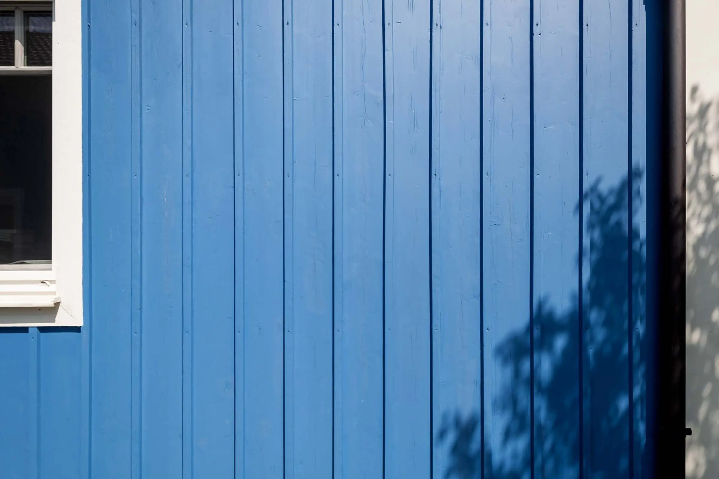 Detailaufnahme einer blauen Holzfassade, Fassaden-Sanierung mit StoColor Dryonic® Wood