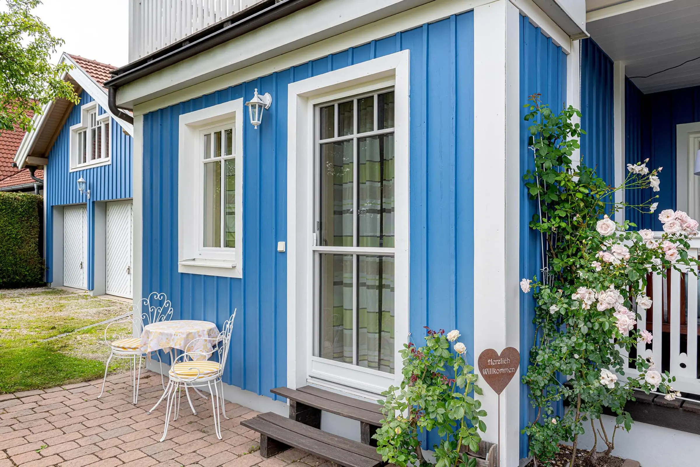 Aufnahme eines blauen Einfamilienhaus mit Garten, Fassaden-Sanierung mit StoColor Dryonic® Wood