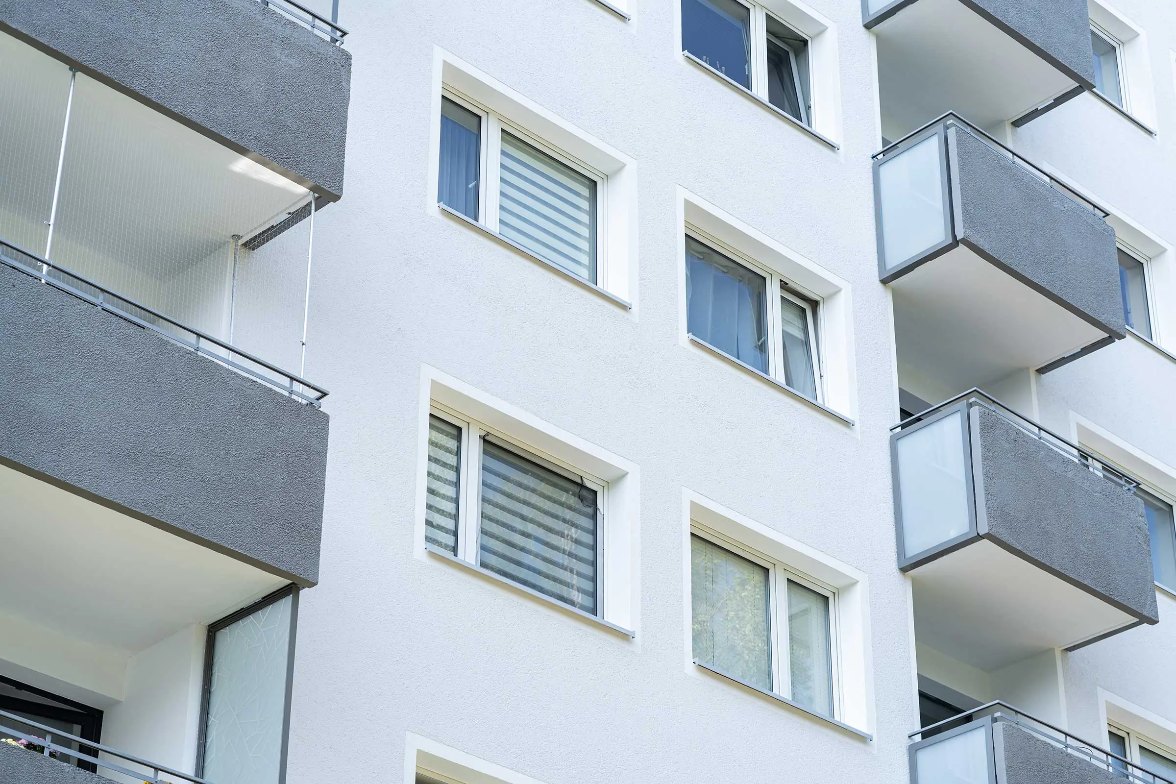 Detailaufnahme Hochhaus mit weiß-grauer Fassade, saniert mit WDVS, Fassadenputz und -farbe von Sto