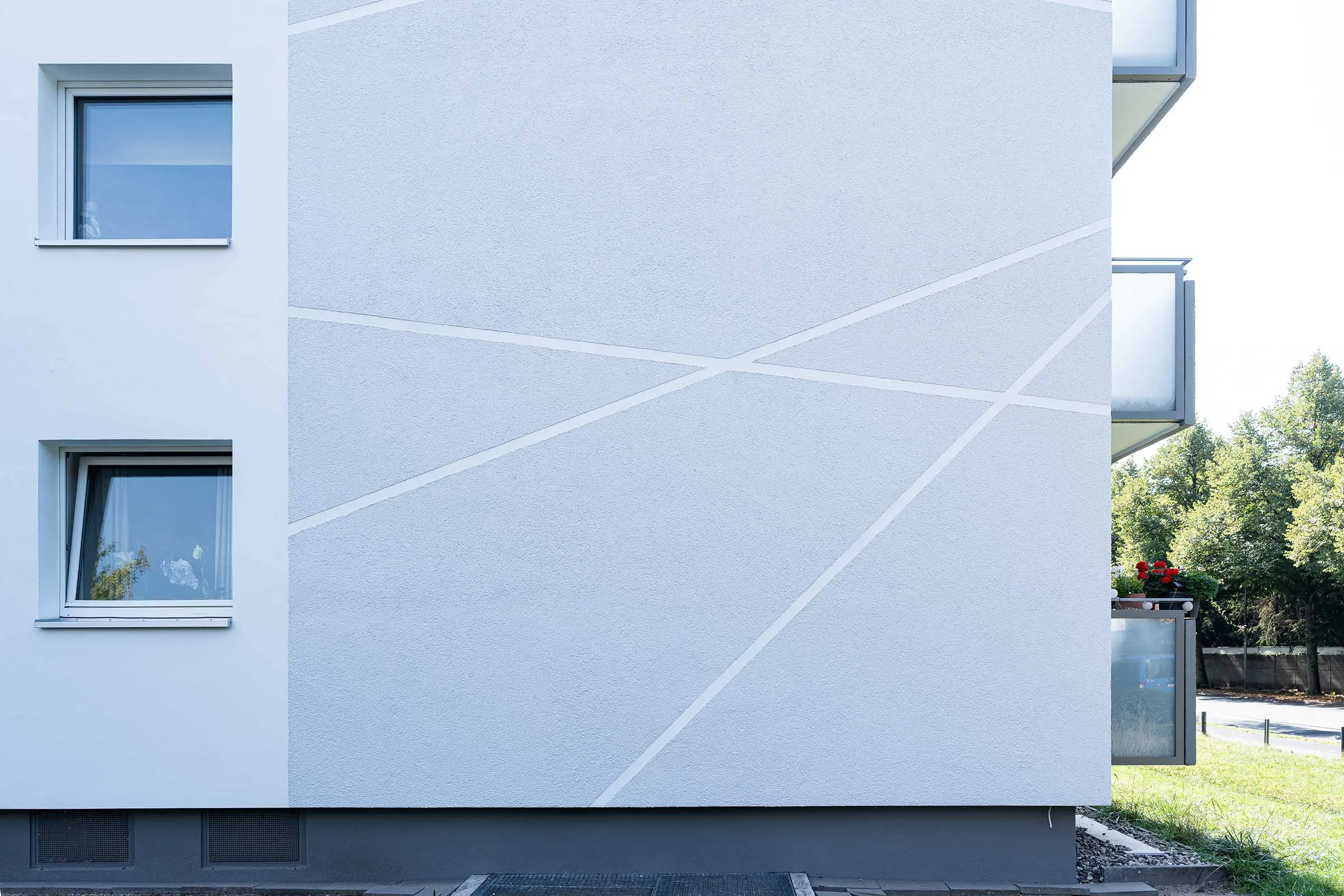 Detailaufnahme Hochhaus mit weiß-grauer Fassade, saniert mit WDVS, Fassadenputz und -farbe von Sto