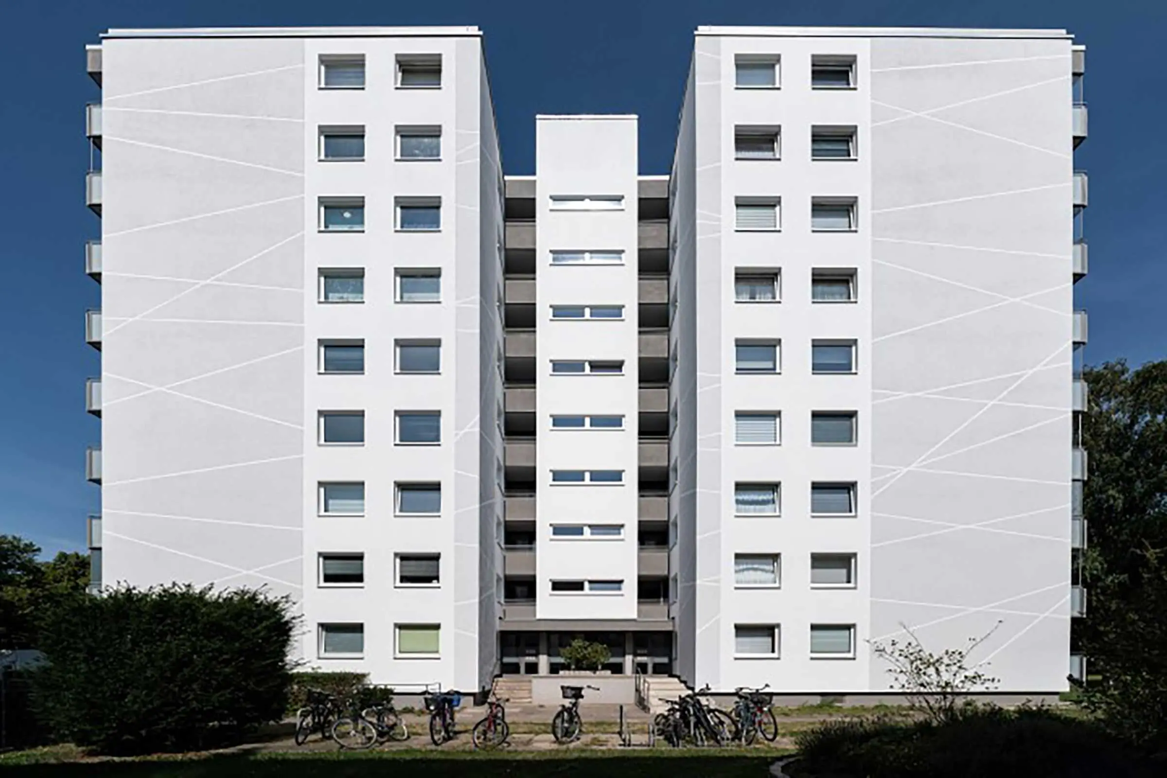 Hochhaus mit weiß-grauer Fassade, saniert mit WDVS, Fassadenputz und -farbe von Sto