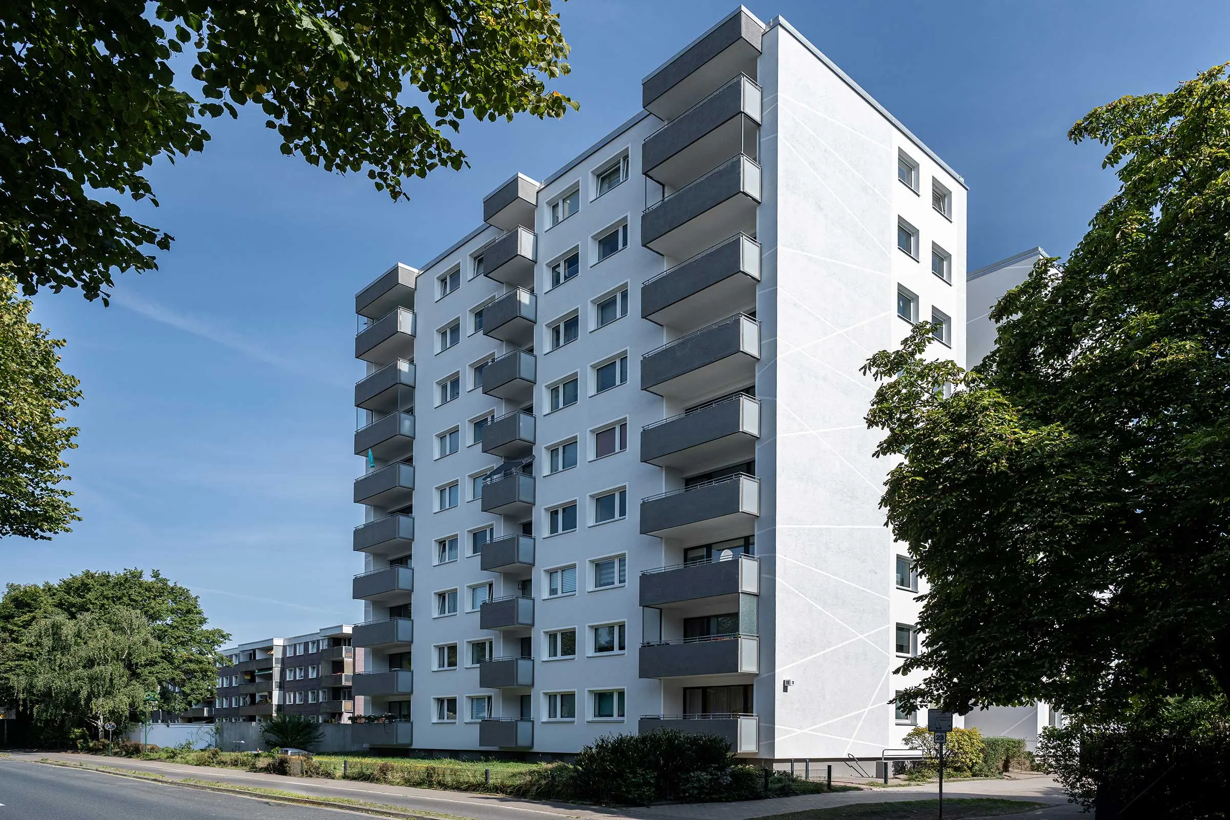 Hochhaus mit weiß-grauer Fassade, saniert mit WDVS, Fassadenputz und -farbe von Sto