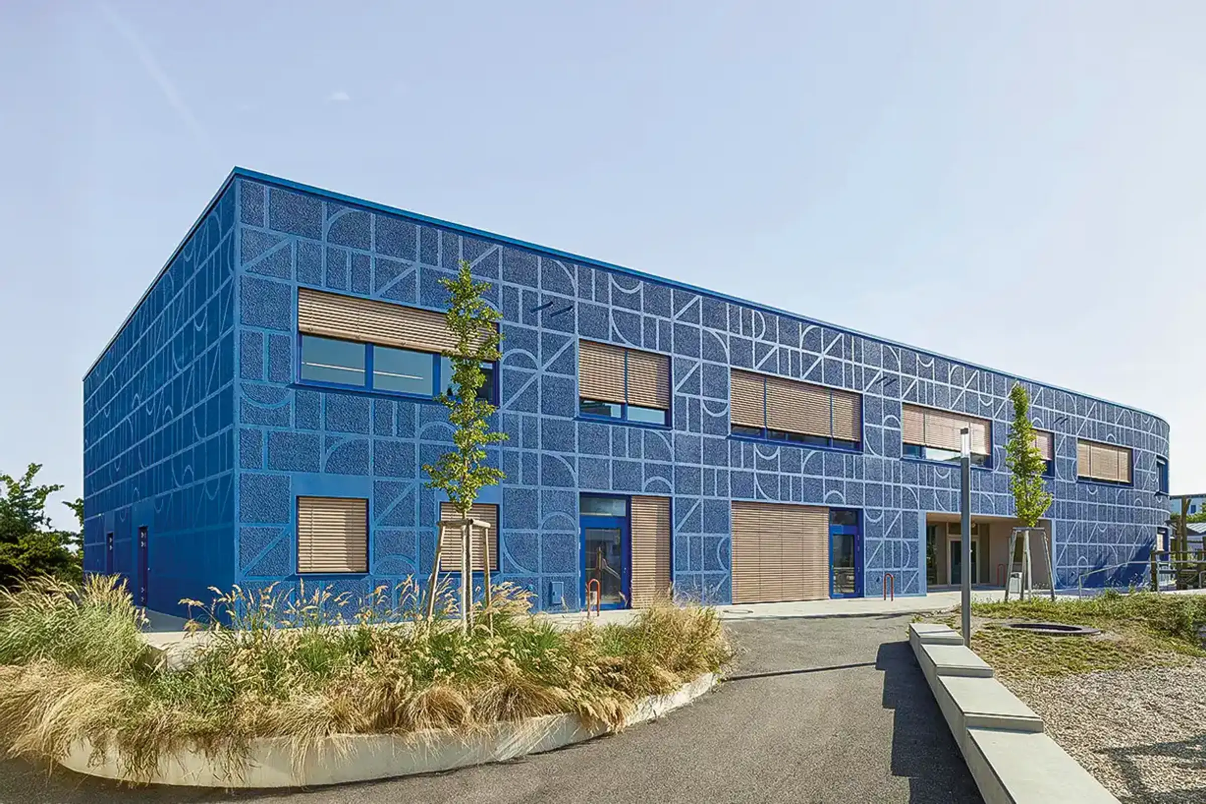 Außenaufnahme einer Schule, Royalblaue Fassade gestaltet mit auffälliger StoSignature Technik