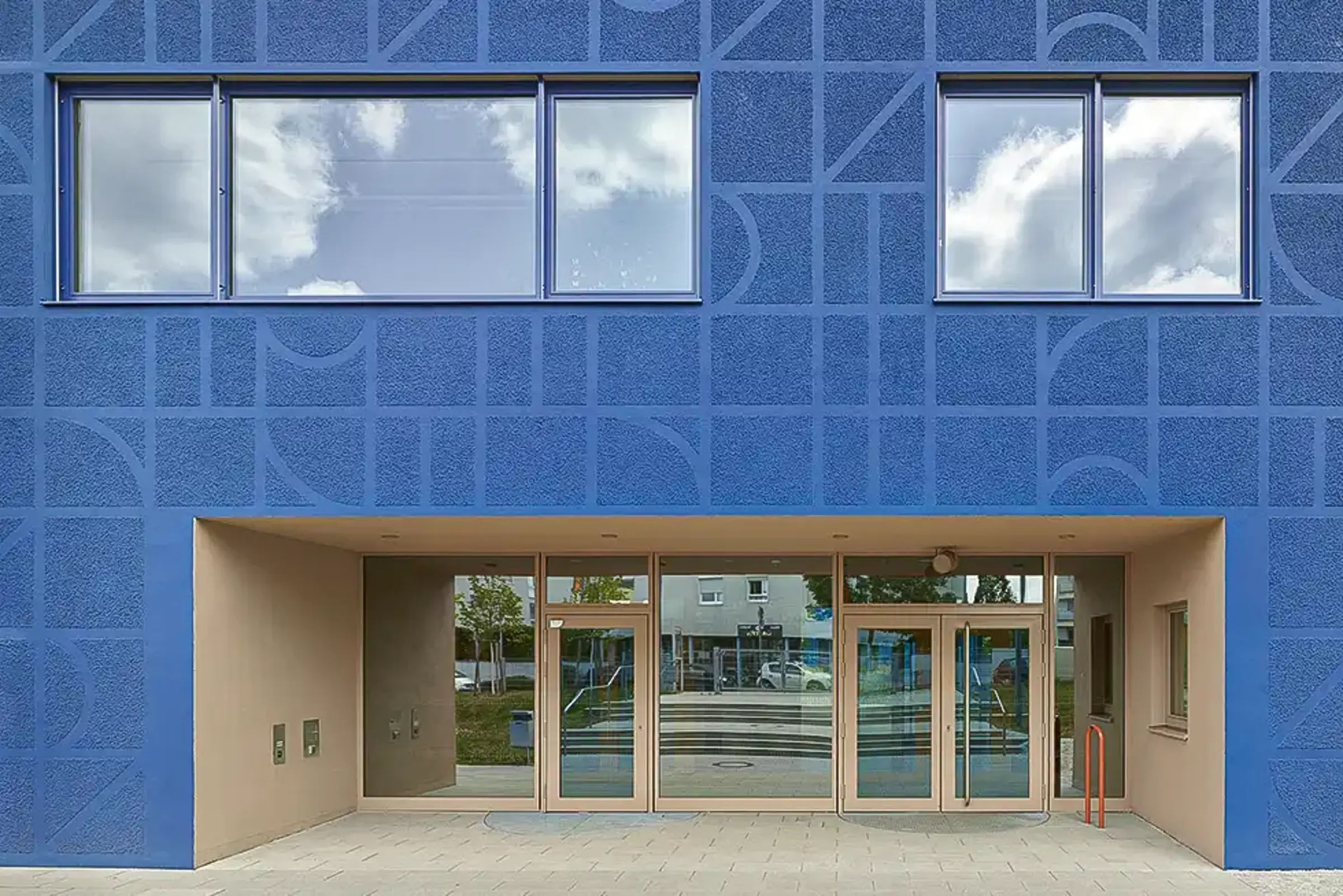 Außenaufnahme einer Schule, Royalblaue Fassade gestaltet mit auffälliger StoSignature Technik