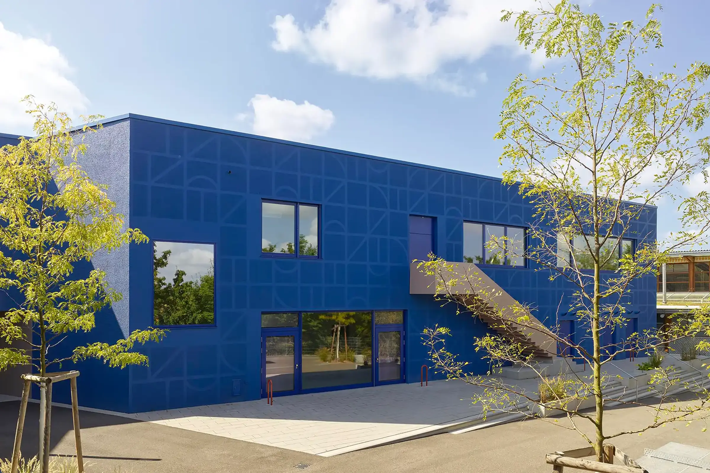 Außenaufnahme einer Schule, Royalblaue Fassade gestaltet mit auffälliger StoSignature Technik