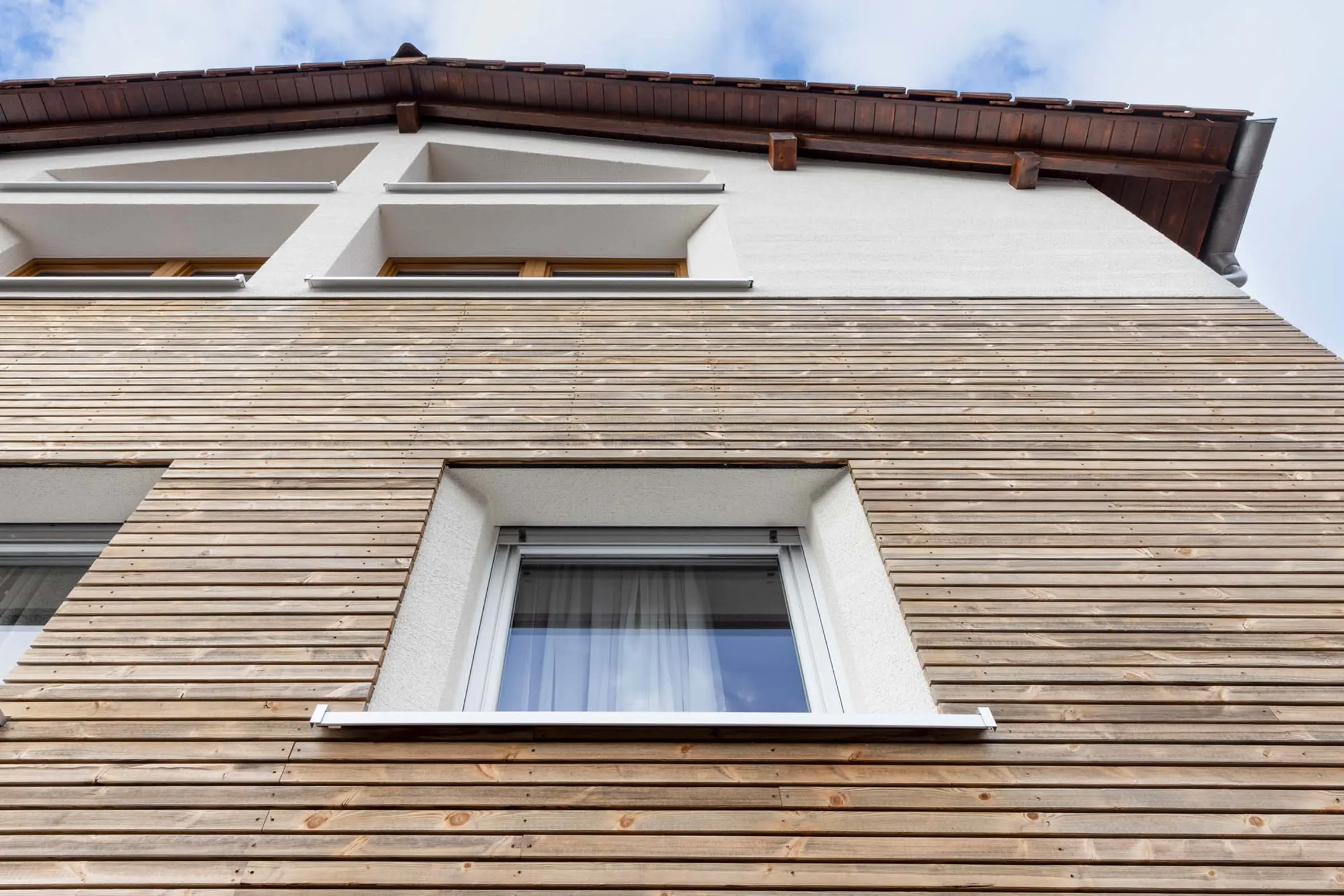 Aufnahme der Holzfassade eines Mehrfamilienhauses, die mit WDVS von Sto gedämmt wurde