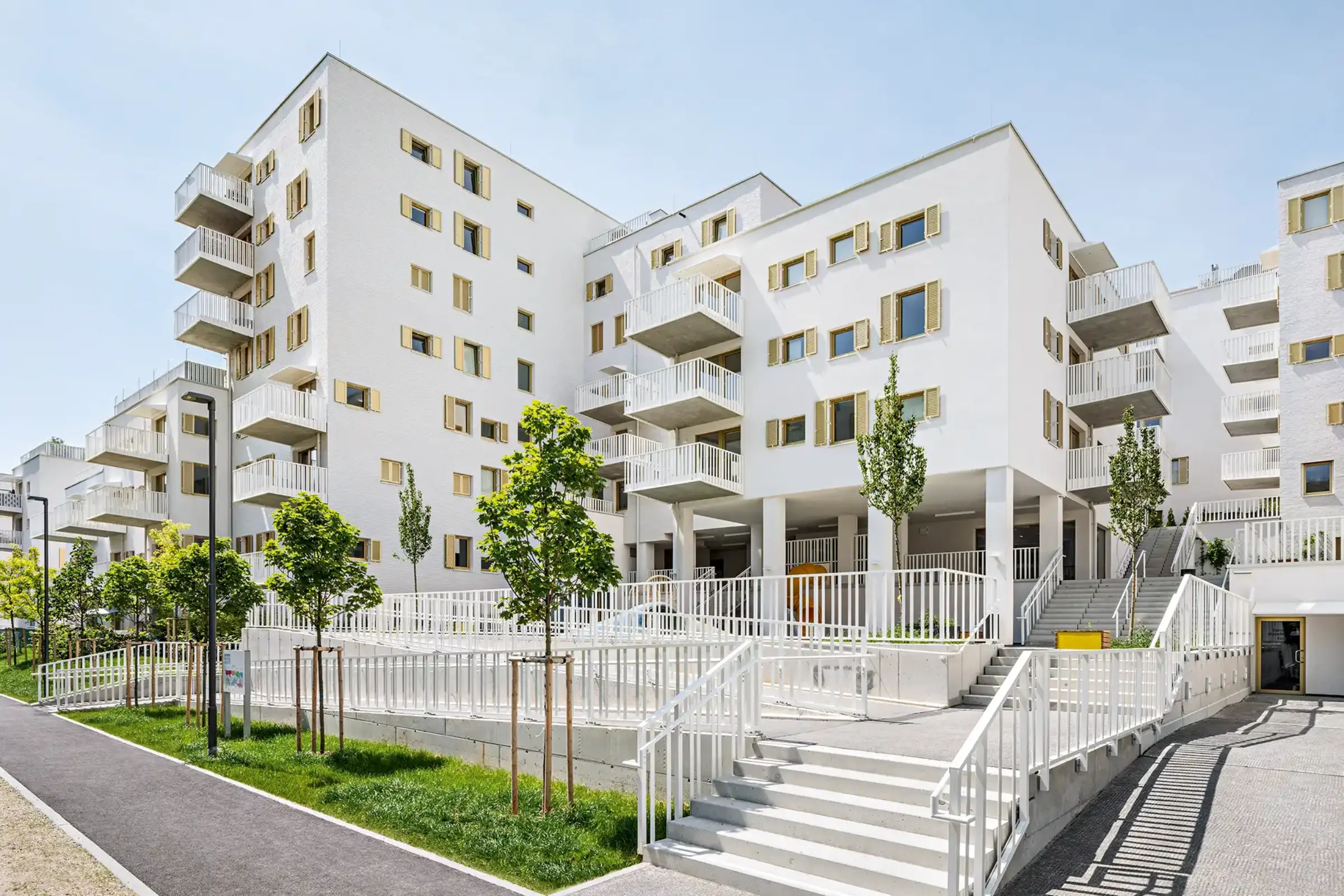 Aufnahme eines Wohnparks, Weiße Klinkerfassaden und goldene Fensterläden