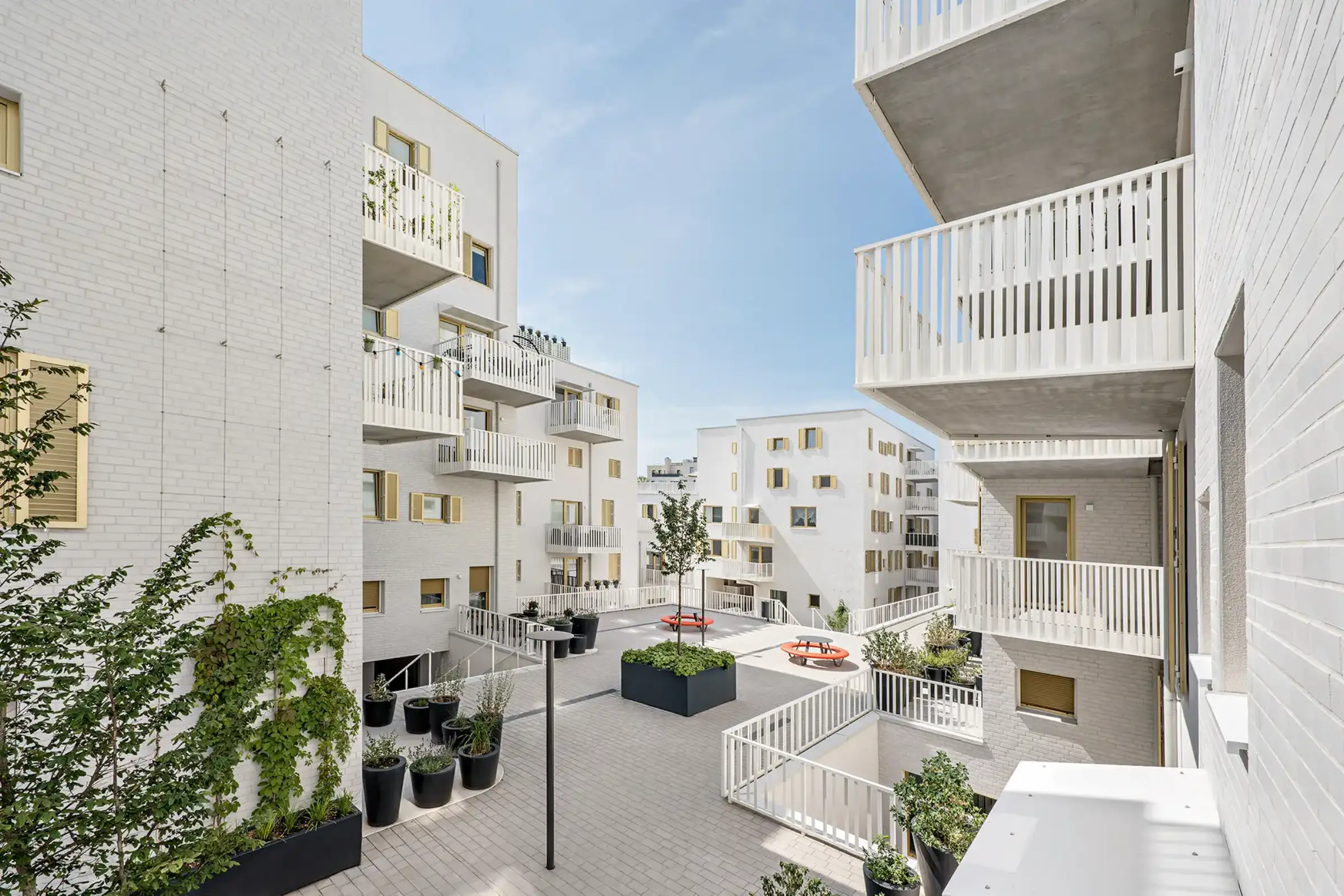 Aufnahme eines Wohnparks, Weiße Klinkerfassaden und goldene Fensterläden